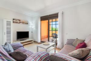 a living room with a couch and a tv at Los Albatros in Ayamonte