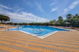 a large swimming pool with blue water and stairs at Los Albatros in Ayamonte