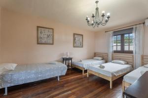 a room with two beds and a chandelier at Casa El Pinito No Groups Under 27 in Tamaide +23 photos