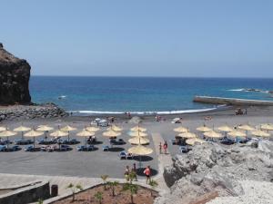 a beach with umbrellas and people on the beach at Salvaje Villa with private Pool in Adeje