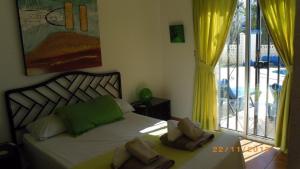 a bedroom with a bed and a window with yellow curtains at Salvaje Villa with private Pool in Adeje +26 photos