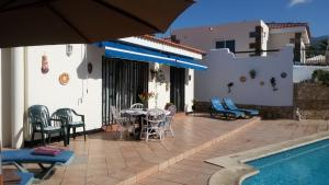 a patio with a table and chairs next to a pool at Salvaje Villa with private Pool in Adeje