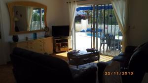 a living room with a couch and a tv and a mirror at Salvaje Villa with private Pool in Adeje