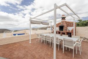 a white table and chairs on a patio next to the beach at Casa El Pinito No Groups Under 27 in Tamaide