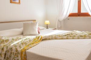 a bed with a yellow and white blanket on it at Villa Vanna Bilo A - bilocale in Capoliveri