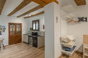 a kitchen with white walls and wooden floors at Mayor 10 in Ejulve