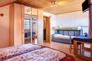 a bedroom with two beds and a desk and a table at Weingartnerhof Calendula in San Genesio Atesino
