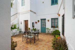 a patio with tables and chairs in a white building at Casa Catalán in Carmona