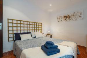 a bedroom with a bed with blue towels on it at Casa Catalán in Carmona