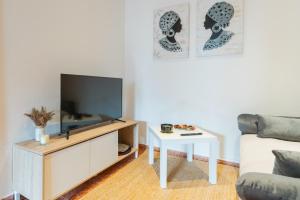a living room with a tv and a table at Casa Catalán in Carmona