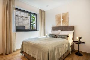 a bedroom with a large bed and a window at Videre Lodge Gantkofel in Gargazzone