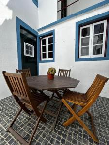 a wooden table with two chairs and a potted plant at Desterro House in Angra do Heroísmo