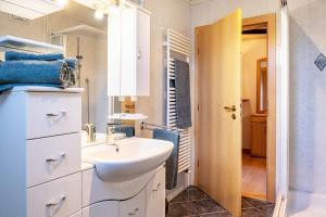 a white bathroom with a sink and a mirror at Weingartnerhof Calendula in San Genesio Atesino
