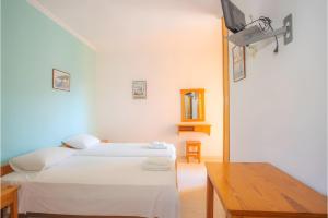 two beds in a room with a tv on the wall at Nidri view Apartments in Nydri