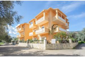 a large yellow building with white balconies on it at Nidri view Apartments in Nydri