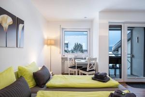a living room with a yellow bed and a table at Schwarzwaldblick F App 3 mit Pool in Schönwald