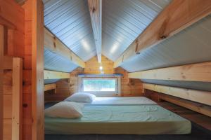 a bed in a wooden cabin with a window at Ty Koad in Plouégat-Moysan +26 photos