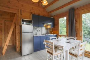 a kitchen with a white table and a refrigerator at Ty Koad in Plouégat-Moysan