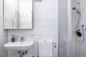 a white bathroom with a sink and a shower at Schwarzwaldblick F App 3 mit Pool in Schönwald +8 photos
