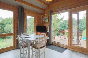 a dining room with a table and chairs on a deck at Ty Koad in Plouégat-Moysan