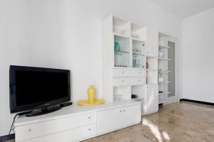 a living room with a tv on a white cabinet at Maison Giovanna with garage parking in Rapallo