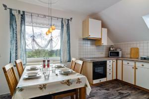 a kitchen with a table with chairs and a window at Arnold Laubbach in Ostrach