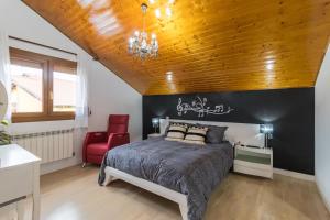 a bedroom with a bed and a red chair at Casa Rural Alojamientos Marte in Hinojedo
