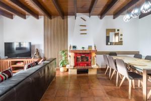 a living room with a fireplace and a table and chairs at Casa Rural Alojamientos Marte in Hinojedo