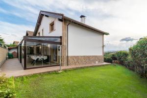 a house with glass doors and a lawn at Casa Rural Alojamientos Marte in Hinojedo