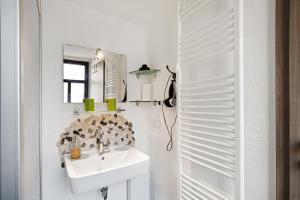a white bathroom with a sink and a mirror at Traumschlüsselchen in Braubach +73 photos