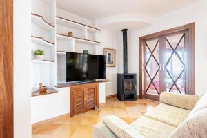 a living room with a tv and a couch at Villas2meet Na Penyal 7 in Cala Millor