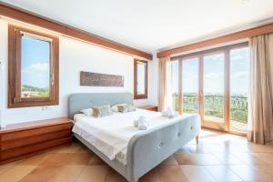a bedroom with a bed and large windows at Villas2meet Na Penyal 7 in Cala Millor +24 photos