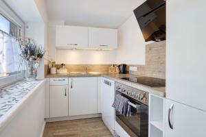 a white kitchen with white cabinets and a sink at Apartment am Tor zu Hamburg in Neu Wulmstorf