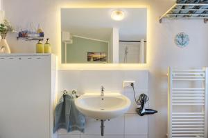 a bathroom with a sink and a mirror at Apartment am Tor zu Hamburg in Neu Wulmstorf +15 photos