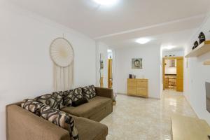 a living room with a couch and a kitchen at Attaday Home Holidays in Ingenio