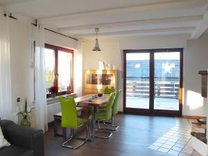 a dining room with a table and green chairs at Ferienhaus Dell in Möhnesee