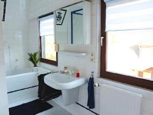 a white bathroom with a sink and a mirror at Ferienhaus Dell in Möhnesee +62 photos