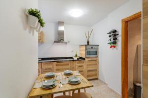 a kitchen with a wooden table with dishes on it at Attaday Home Holidays in Ingenio