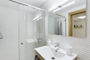a white bathroom with a sink and a mirror at Attaday Home Holidays in Ingenio +20 photos