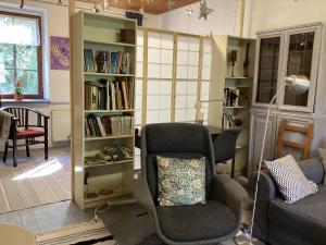 a living room with a chair and a book shelf at Ferienwohung zum Wasserfall in Üxheim