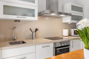 a kitchen with white cabinets and a sink at Beach Center Only 150 M Luxury in Fuengirola