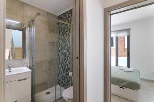 a bathroom with a shower and a toilet and a sink at Casa Lopes in Fuzeta +13 photos