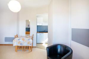 a dining room with a table and a chair at Les Mimosas - Appartement 08 in Cazaubon