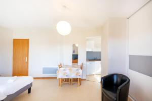 a bedroom with a bed and a table and a chair at Les Mimosas - Appartement 08 in Cazaubon