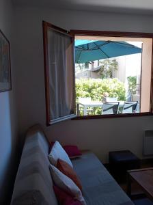 a living room with a couch and a window with an umbrella at Gîte Capibay Les Herbes de Provence in Six-Fours-les-Plages