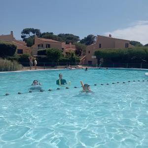 a group of people swimming in a swimming pool at Gîte Capibay Les Herbes de Provence in Six-Fours-les-Plages