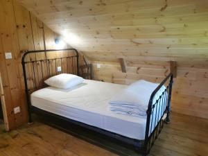 a bedroom with a bed in a log cabin at Gîte La Forge Faverolles in Arcomie