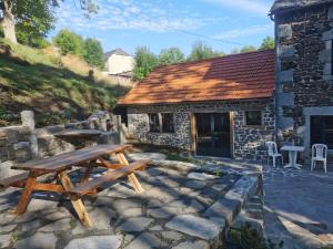 a picnic table in front of a stone building at Gîte La Forge Faverolles in Arcomie
