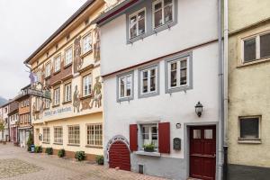 a white building with red doors on a street at Fachwerkhaus Für Dich in Eberbach