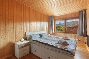 a bedroom with a bed in a wooden wall at Frenkhausener Ruhepol in Meschede